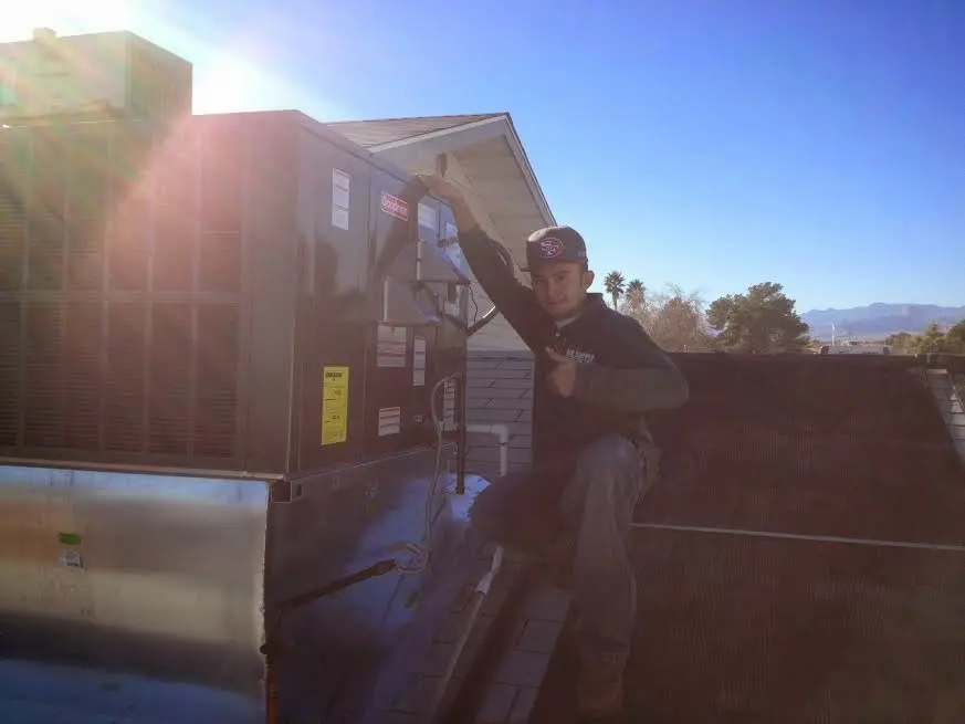 HVAC technician performing Air Duct Cleaning on a rooftop unit in Galax